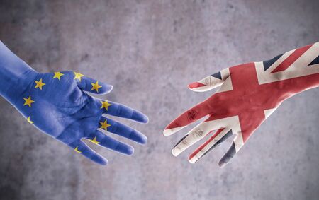 Hands painted with UK and European flag reaching out for a handshakeの写真素材