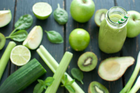 Green smoothie bottle with straw and ingredientsの写真素材