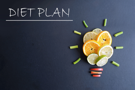 Diet plan to do list next to fruits in the shape of a light bulbの写真素材