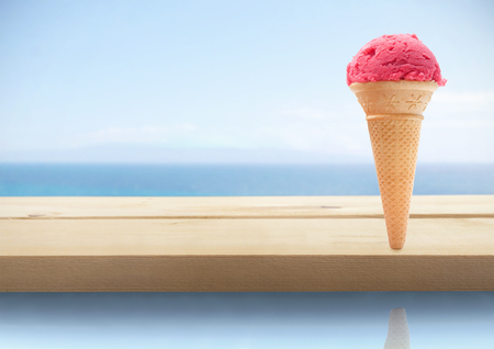 Strawberry icecream cone by a pool sideの写真素材