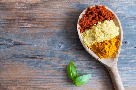 Mix of spices in a wooden spoon over a wooden backgroundの写真素材