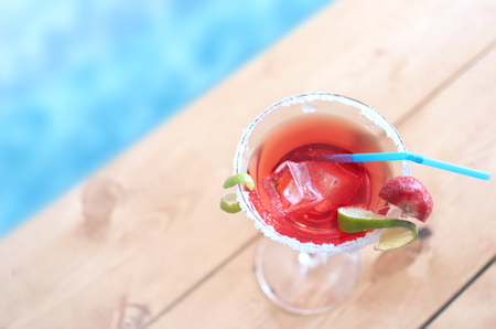 Cocktail beverage with lime and ice by a swimming poolの写真素材
