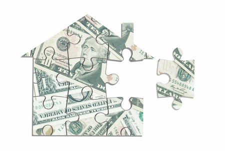 Dollar house jigsaw puzzle over a white backgroundの写真素材