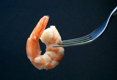 Cooked prawn on a fork close upの写真素材