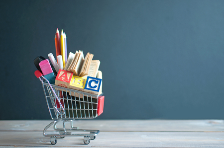 Shopping cart filled with stationery merchandise against chalkboardの写真素材