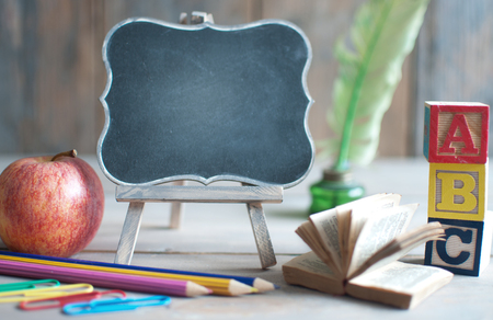 Empty blackboard with school stationery, and appleの写真素材