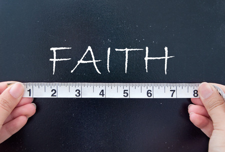 Hands measuring faith on a chalkboardの写真素材