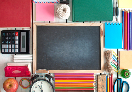 Top view of many stationery objects with blackboard in the centreの写真素材