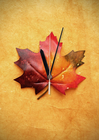 Autumn maple leaf with clock hand daylight savingsの写真素材