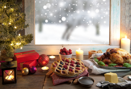 Christmas roast meal setting with winter snow through a window の写真素材