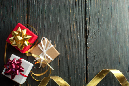 Christmas presents wrapped with ribbon over a wooden backgroundの写真素材