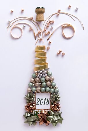 Open champagne bottle made from decorations including baubles and ribbonの写真素材
