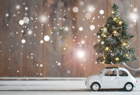 Christmas tree with lights on top of a toy car の写真素材