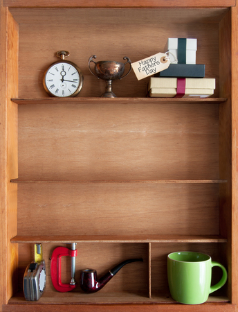 Fathers day gift with label inside a shelf with various objects including tools and coffee cupの写真素材
