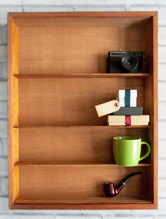 Gift box with blank label inside a display shelf with coffee cup and pipeの写真素材