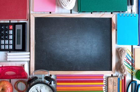 Top view of various stationery objects with blackboard in the centreの写真素材