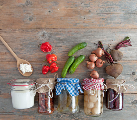 Naturally fermented foods in jars including kefir, gherkins and peppers and onionsの写真素材