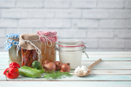 Naturally fermented foods in jars including kefir, gherkins and peppers and onionsの写真素材
