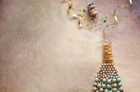 Champagne bottle made from decorations including baubles and ribbonの写真素材
