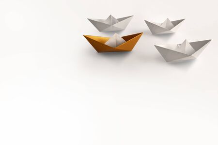 Gold paper boat standing out amongst other boatsの写真素材