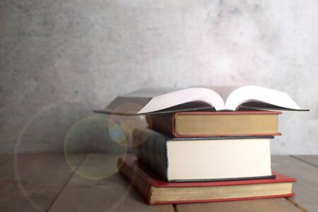 Open book on top of a stack of booksの写真素材