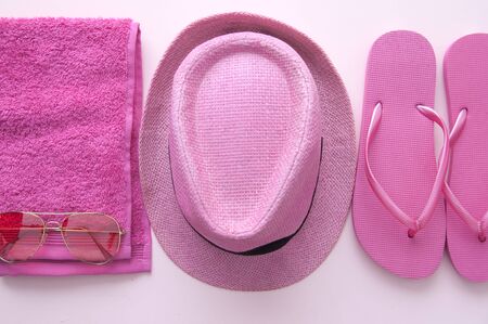 Pink summer accessories including towel, flip flops, hat and sunglassesの写真素材