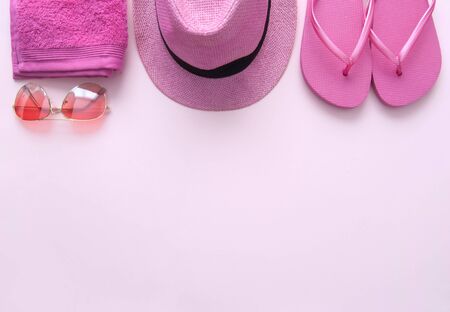 Pink summer accessories including towel, flip flops, hat and sunglassesの写真素材