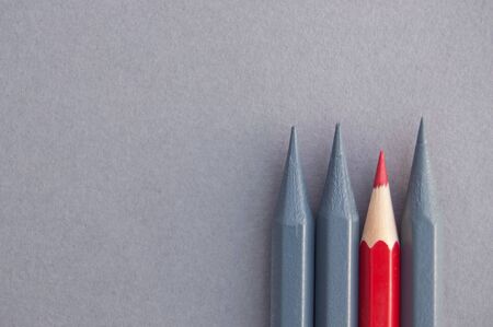 Red pencil amongst greyed out pencils の写真素材