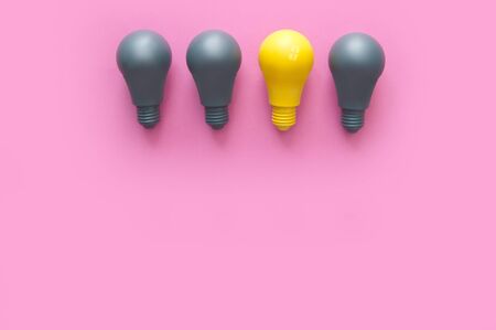 Yellow light bulb standing out amongst grey の写真素材