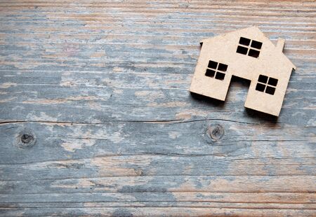 Small miniature house over a wooden background with space の写真素材