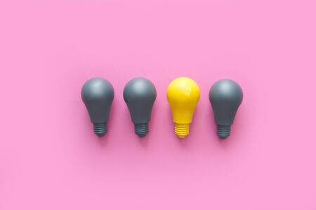 Yellow light bulb standing out amongst grey の写真素材