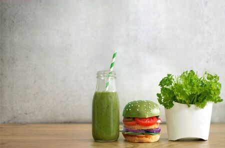 Green burger, vegetable smoothie and salad in a french fries containerの写真素材