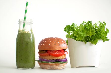 Healthy fast food, burger and vegetable smoothie and salad in a french fries containerの写真素材