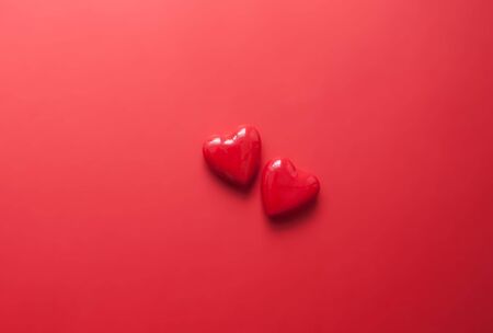 Two red hearts on red backgroundの写真素材