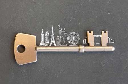 Gold key with skyline sketch of global landmarksの写真素材