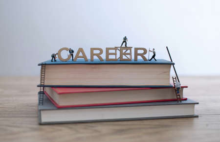 Miniature construction builders working around block letters spelling the word careerの写真素材