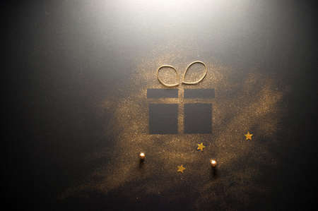 Gift box icon shape with ribbon made with gold glitterの写真素材