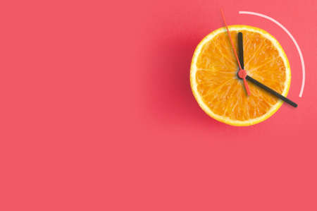 Orange with clock hands, eight hour intermittent fasting diet conceptの写真素材