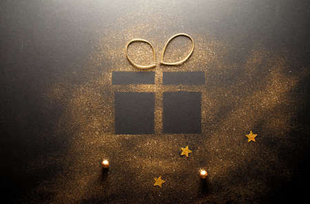Gift box icon shape with ribbon made with gold glitterの写真素材