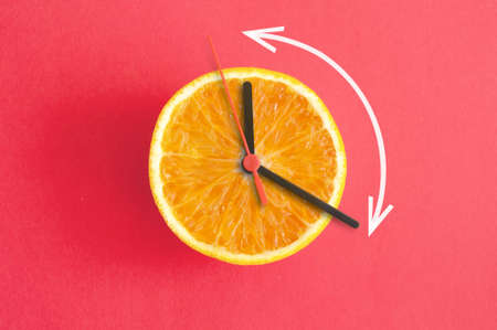 Orange with clock hands, eight hour intermittent fasting diet concept