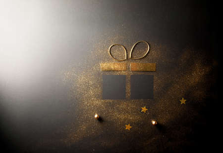 Gift box shape made with gold glitter and ribbon bowの写真素材