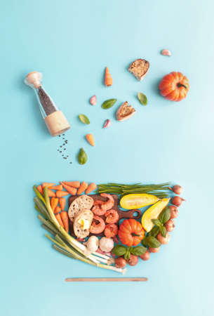 Autumn thanksgiving soup ingredients laid flat in the shape of a bowl including squash, pumpkin and onionsの写真素材