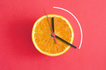 Orange with clock hands, eight hour intermittent fasting diet conceptの写真素材