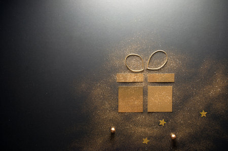 Decorative gold gift box icon made with glitter and cardの写真素材