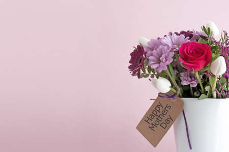 Gift bouquet flowers in a white vase and empty labelの写真素材