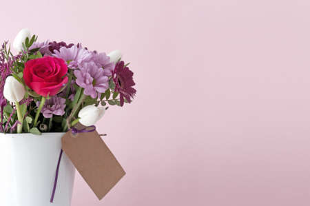 Gift bouquet flowers in a white vase and empty labelの写真素材
