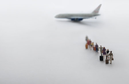 Miniature people, vacation travellers in queue ready to board aeroplane flightの写真素材