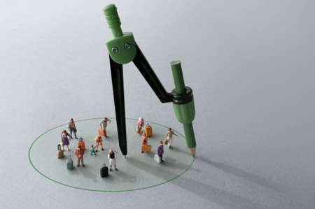 Compass with green pencil circle around miniature travellers representing restriction free zones