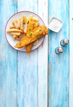 Traditional fish and chips on a plate over rustic wood tableの写真素材