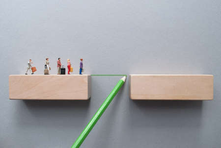 Miniiature travellers crossing a bridge drawn by green pencilの写真素材